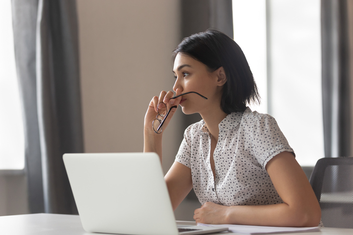 woman sitting at computer looking pensive